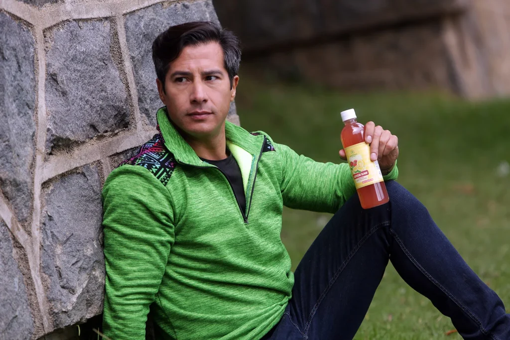 Botella de limonada Lemon Raw sabor sandía en fondo de colores vivos. con modelo